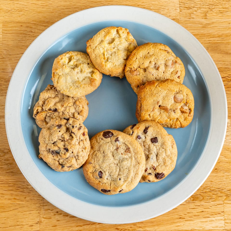 Assortment of freshly baked cookies, including chocolate chip, oatmeal raisin, and white chocolate macadamia nut.
